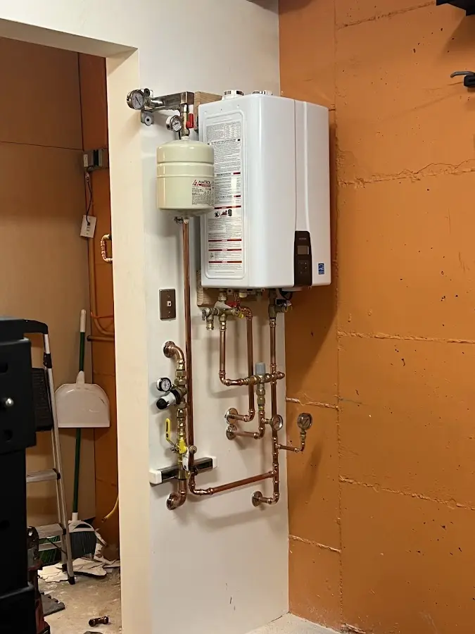 Plumbing technician inspecting water heater connections in Berwyn Heights